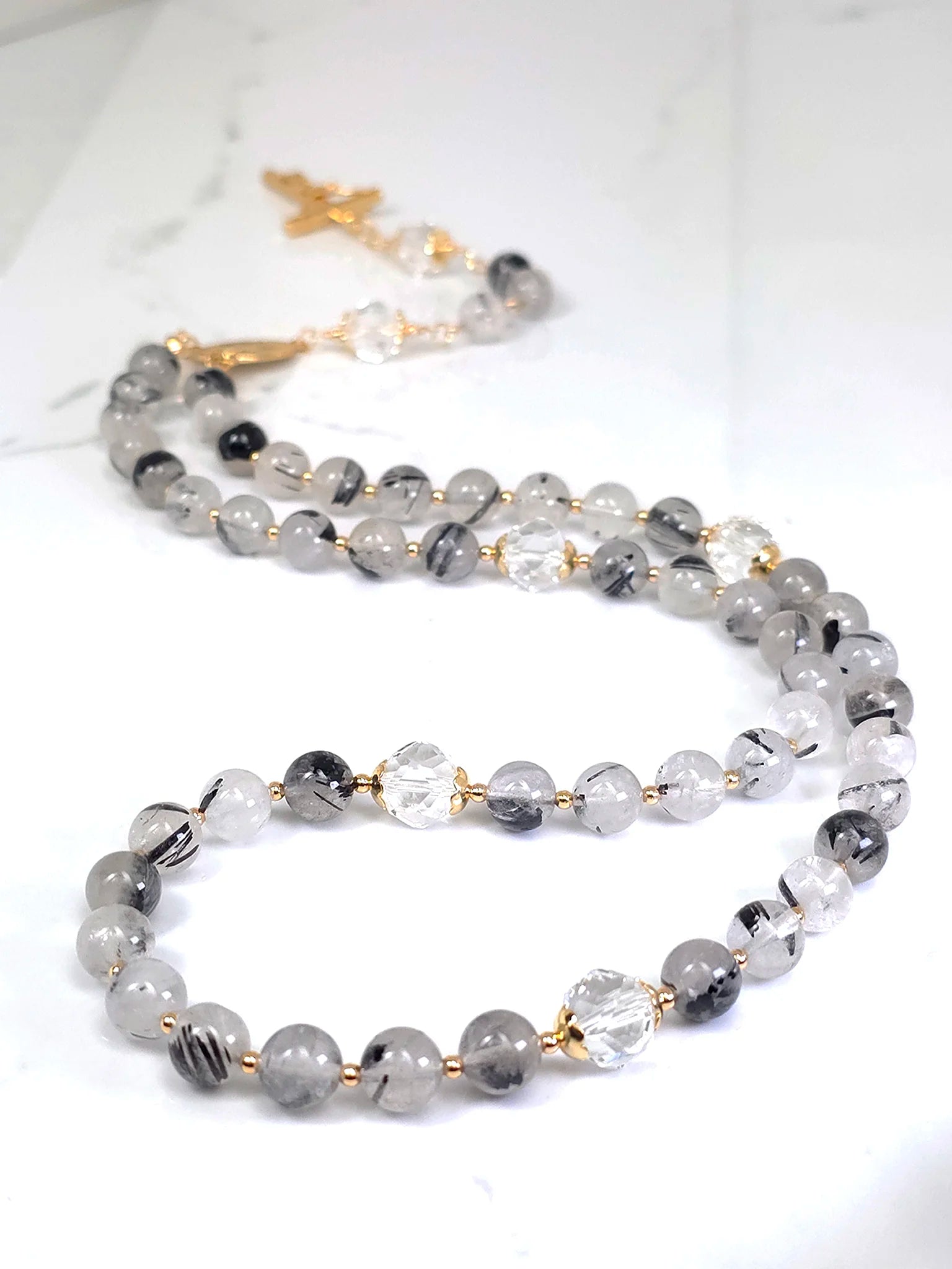 Elegant necklace highlighting the beauty of Black Tourmaline rutilated Quartz, adorned with a distinct Gold Madonna center.