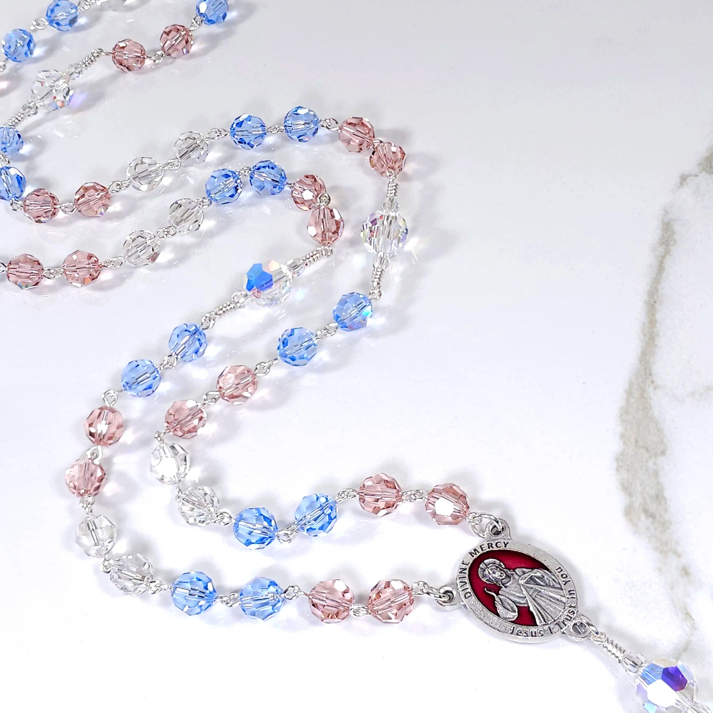 Handcrafted Divine Mercy rosary with red, white, and blue crystals symbolizing divine love and mercy.