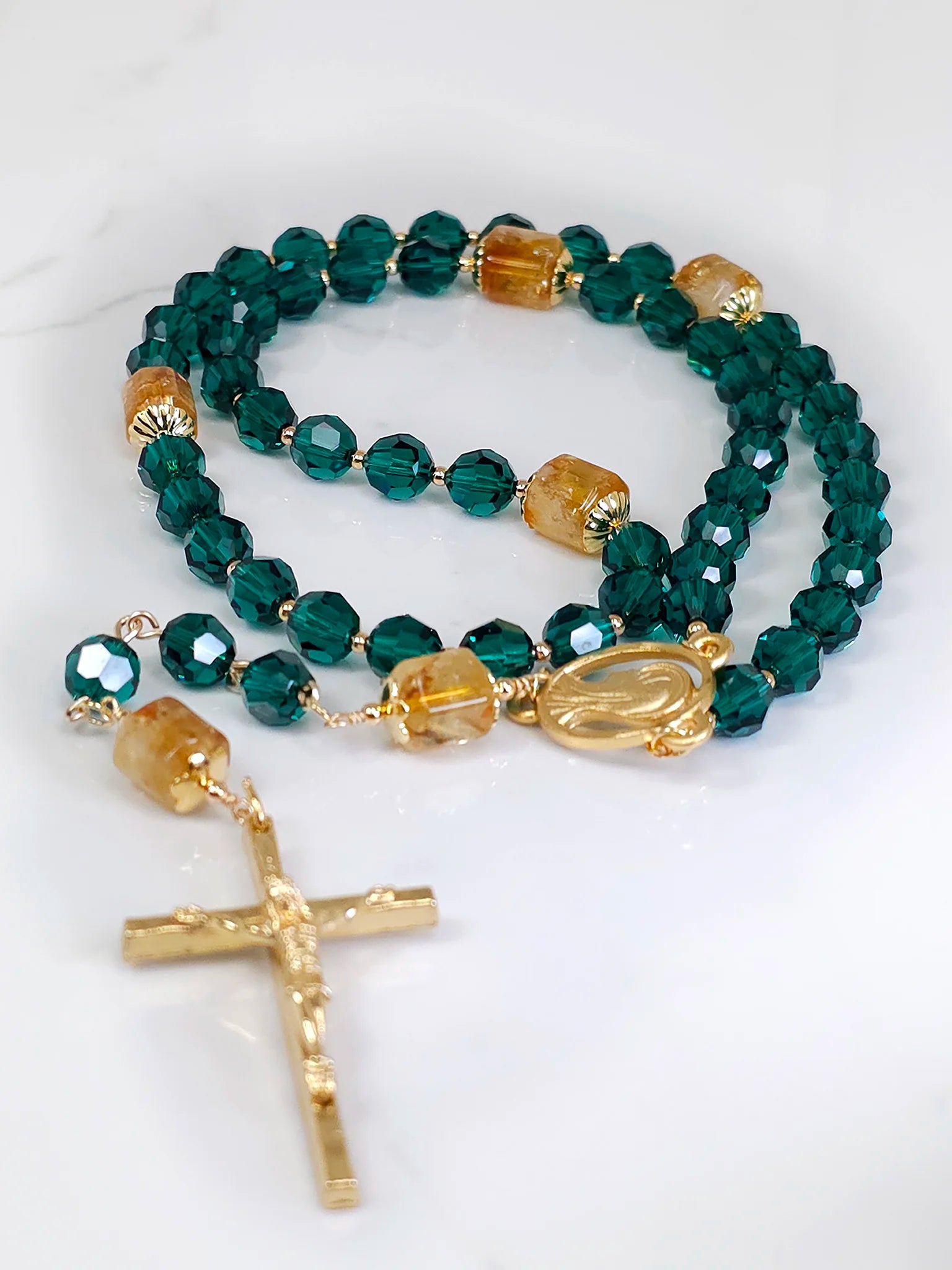 Necklace design highlighting the shimmer of emerald crystals, elegantly arranged on a white surface.