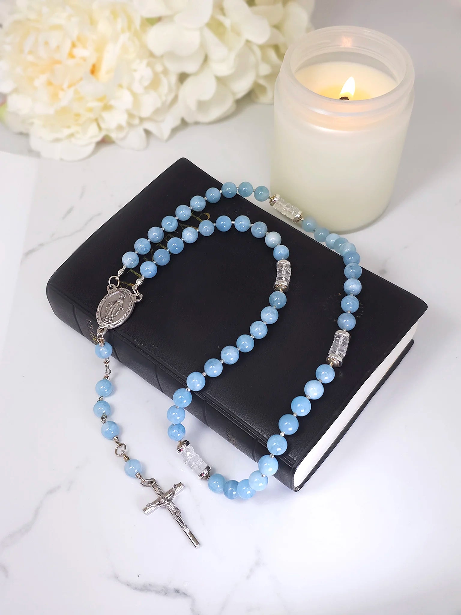 Catholic rosary showcasing blue gemstones, Italian Crucifix pendant, and Virgin Mary centerpiece.