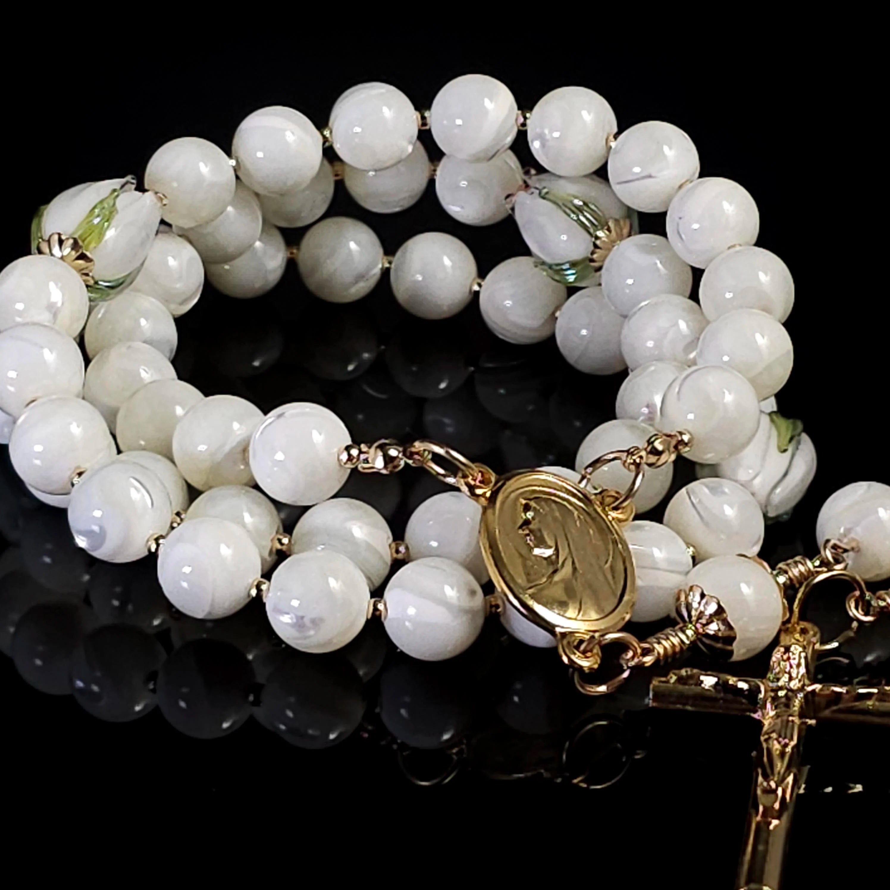 Pearl white rosary adorned with gold Madonna medal.