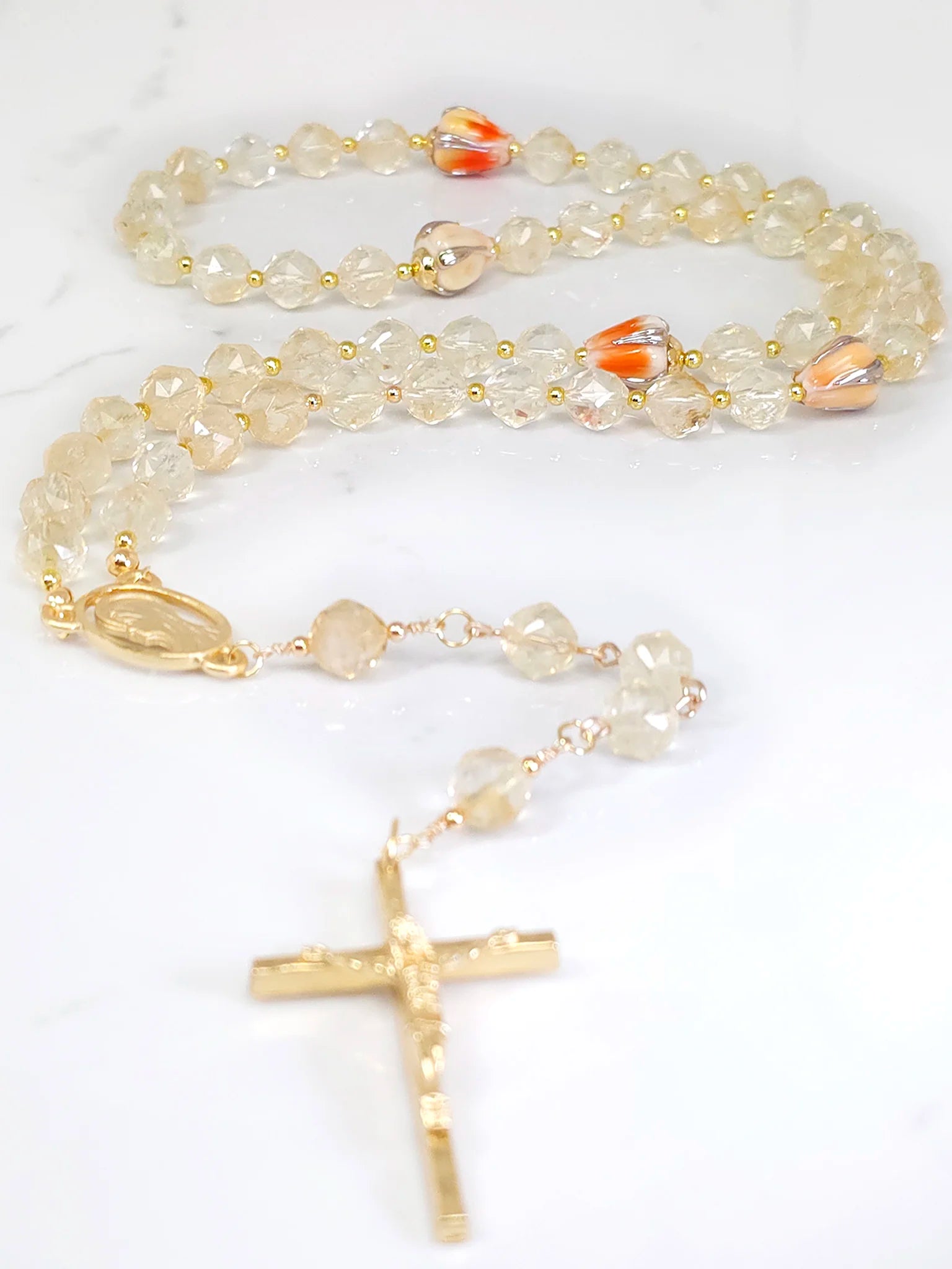 Gold-plated rosary showcasing gold citrine beads and ornate orange floral beadwork.