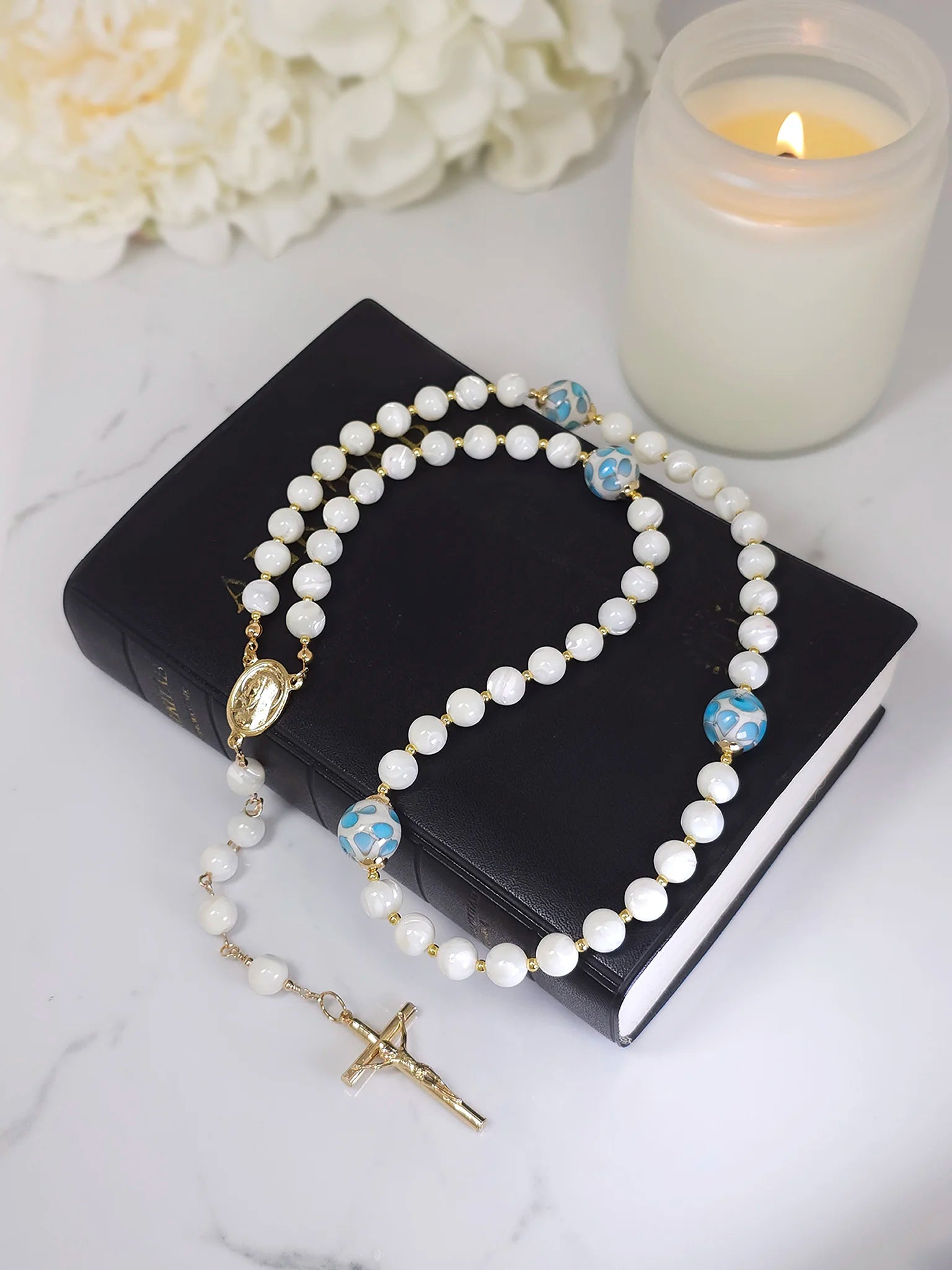 Rosary crafted from White Mother of Pearl beads, accentuated by little blue flower glass beads and a Gold Crucifix pendant.
