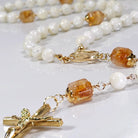 Star of the sea rosary laying on white marble.