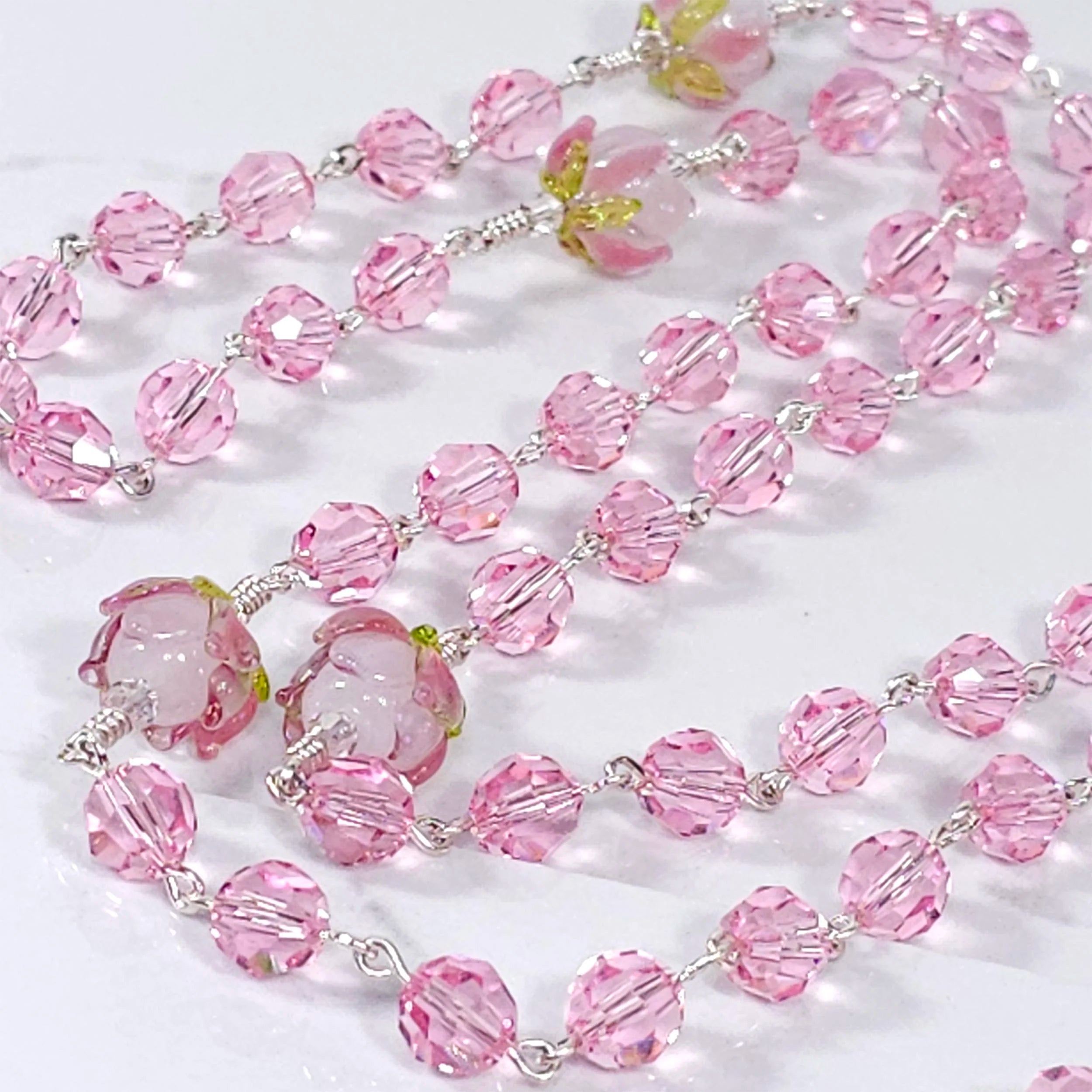 Pink genuine Swarovski crystal rosary adorned with rose flower glass beads.